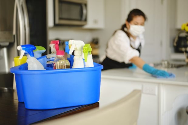 A professional housecleaner at work cleaning a home.